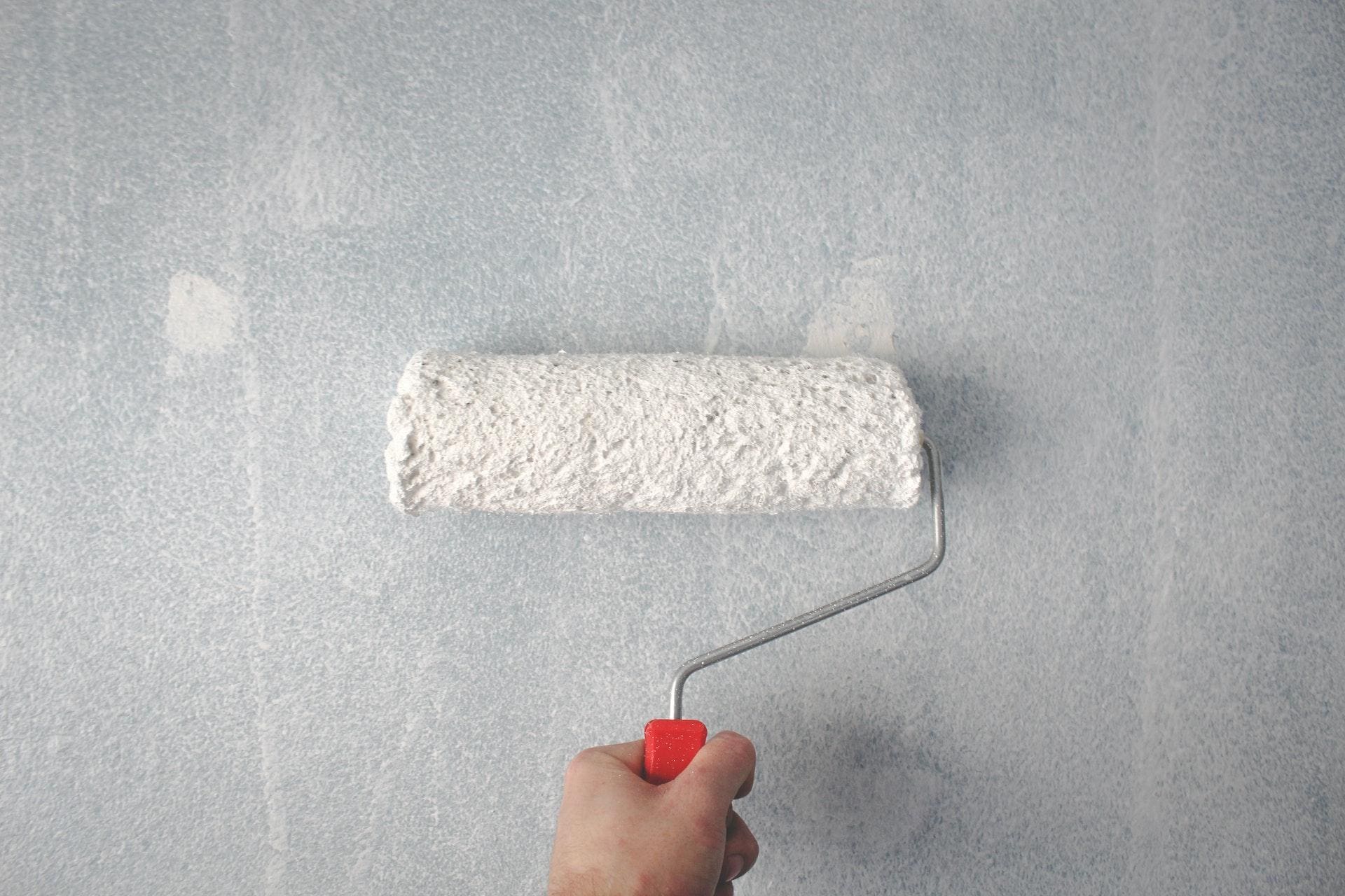 A painter applying paint on a wall.